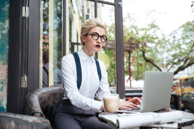 Dizüstü bilgisayar ile çalışan düşünceli genç güzel kadın