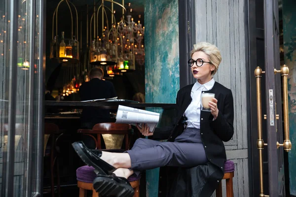 Красива стильна дівчина сидить в кафе і читає журнал — стокове фото