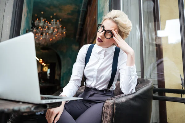 Beautiful younf tired blonde woman working with laptop outdoors — Stock Photo, Image