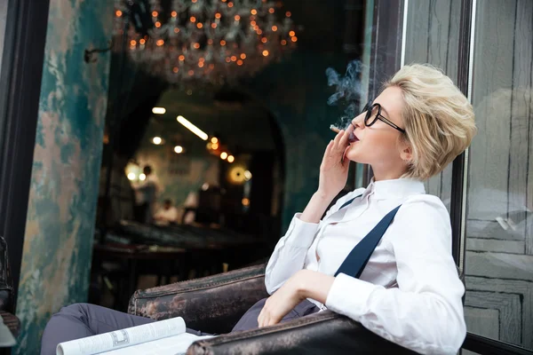 Entspannte junge Frau raucht Zigarette im Café — Stockfoto