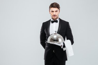 Garson servis tepsisi cloche ve peçete ile tutarak smokin