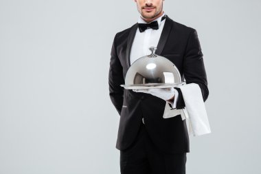 Butler smokin ve kapak ile gümüş tepsi tutarak eldiven