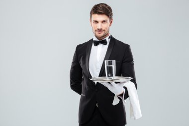 Butler bardak su gümüş tepsi üzerinde tutarak eldiven
