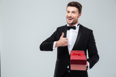 Adam mevcut kutusu tutarak ve başparmak gösterilmesini smokin