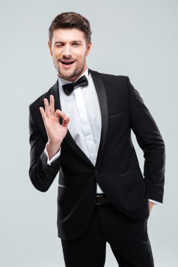 Smokin genç adam ok işaret gösteren papyon ile gülümseyen