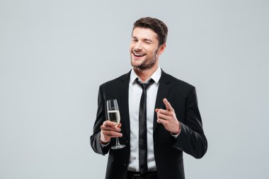 Şampanya içmek ve sana işaret mutlu yakışıklı genç işadamı