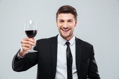 Gülümseyen ve kırmızı şarap içme Cheeful genç iş adamı