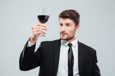 Ciddi adam sommelier bardak kırmızı şarap tatma Suite