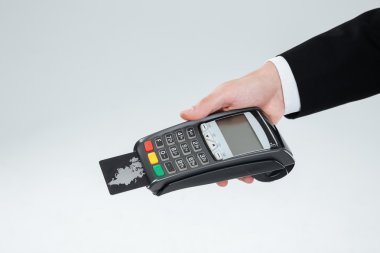 Hand of businessman holding bank terminal with credit card clipart