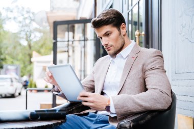 Tablet pc dokunma açık bir kafede olan genç adam