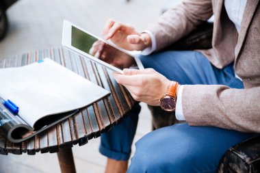 Adam oturmuş ve açık kafede tablet kullanma