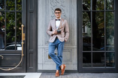 Mutlu adam komik gözlük eski vintage fotoğraf kamera tutarak