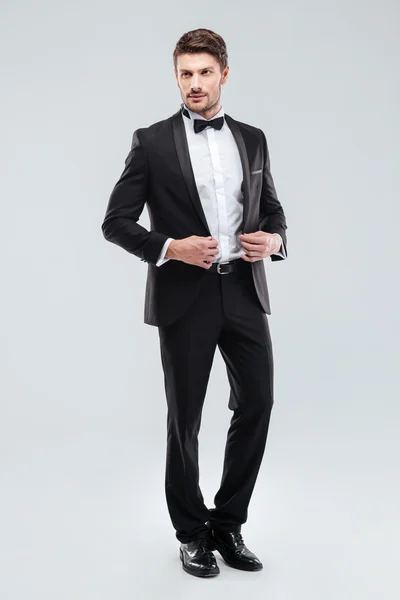 Full length of handsome young man in tuxedo with bowtie — Stock Photo, Image