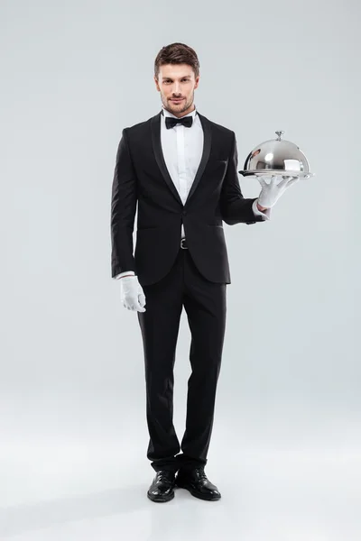 Handsome young man waiter holding tray and lid — Stock Photo, Image