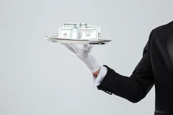 Bandeja con el dinero sostenido por la mano del camarero en guante — Foto de Stock