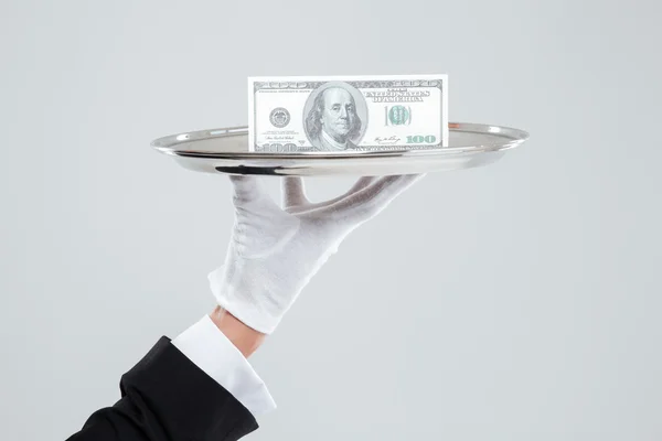 Hand of waiter in white glove holding tray with dollars — Stock Photo, Image