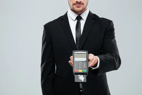 Businessman in black suit holding bank terminal with credit card — Stock Photo, Image