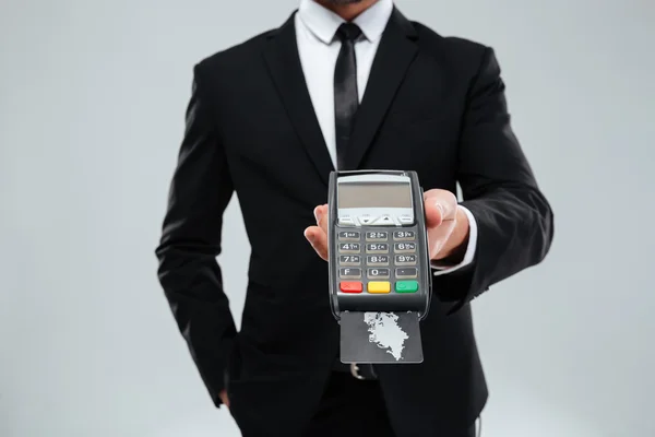 Großaufnahme eines Geschäftsmannes, der ein Zahlungsterminal mit Kreditkarte hält — Stockfoto