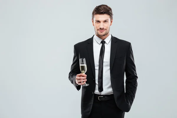 Впевнений чоловік у костюмі і краватці тримає келих шампанського — стокове фото