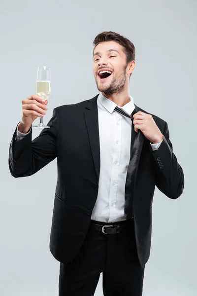 Веселый молодой бизнесмен пьет шампанское и празднует — стоковое фото
