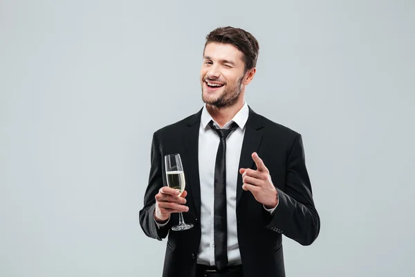 Счастливый красивый молодой бизнесмен пьет шампанское и указывает на тебя. — стоковое фото