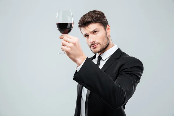 Sommelier erkek tadımı ve kırmızı şarap cam bakıyor — Stok fotoğraf