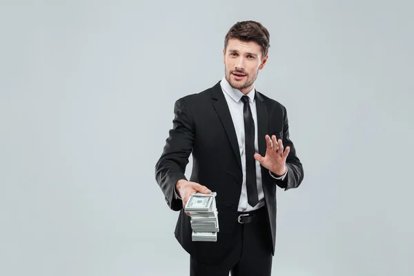 Attractive businessman in suit and tie giving you money back — Stock Photo, Image