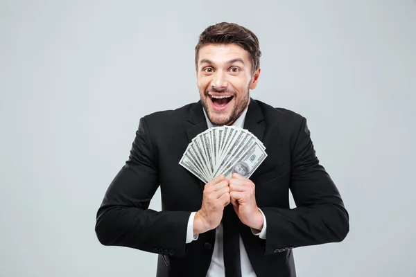 Alegre joven empresario emocionado riendo y sosteniendo el dinero — Foto de Stock