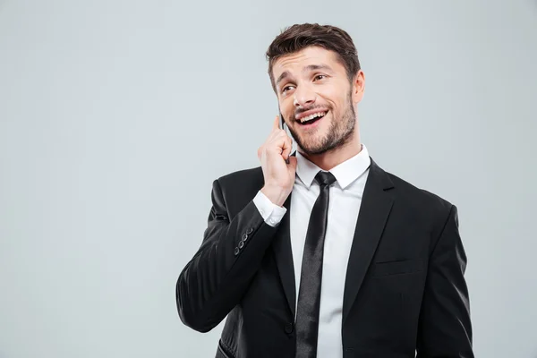 Jovem empresário alegre falando no celular — Fotografia de Stock