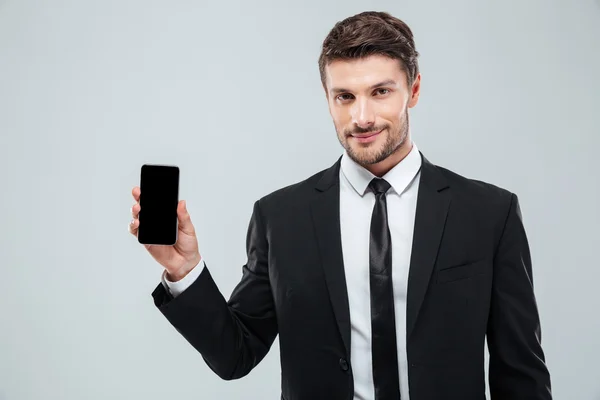 Telefon komórkowy pustego ekranu wyświetlone jest atrakcyjny młody biznesmen — Zdjęcie stockowe