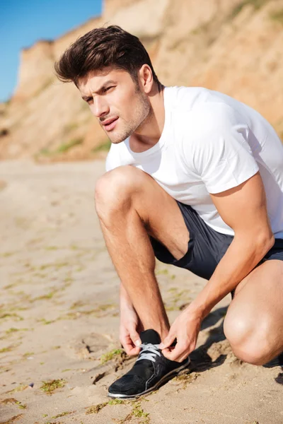 Человек готовится к пробежке по пляжу — стоковое фото
