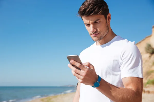 Sportman met fitness tracker en smartphone buitenshuis — Stockfoto