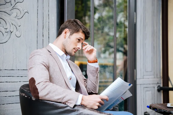 Negocios leyendo el periódico al aire libre en la cafetería — Foto de Stock