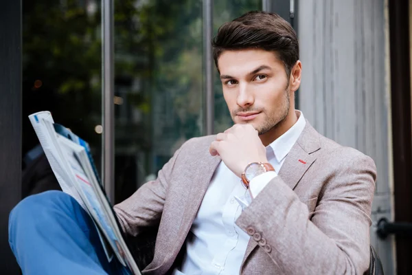 Man relaxing and reading magazine in outdoor cafe — Stock Photo, Image