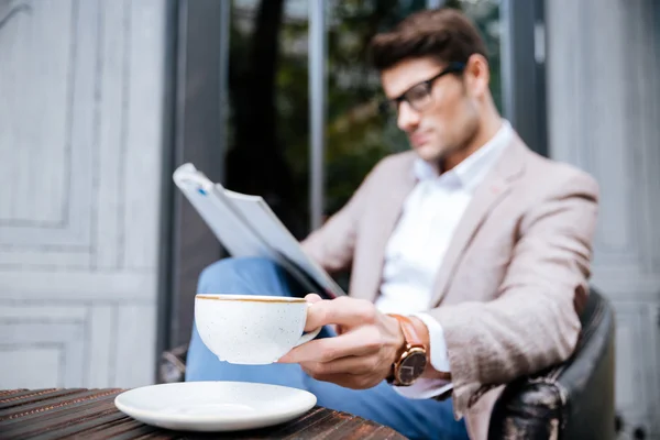 Hombre reflexivo con taza de café revista de lectura en la cafetería —  Fotos de Stock