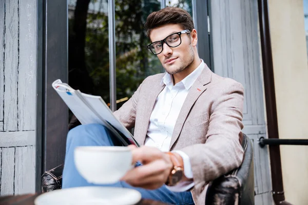 Confiante relaxado jovem leitura revista no café ao ar livre — Fotografia de Stock