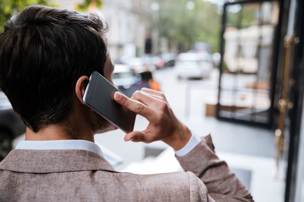 Vedere din spate a omului vorbind pe telefonul mobil pe stradă — Fotografie, imagine de stoc