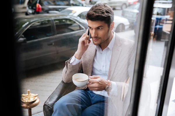 Businessman talking on the phone in a coffee shop — Stock Photo, Image