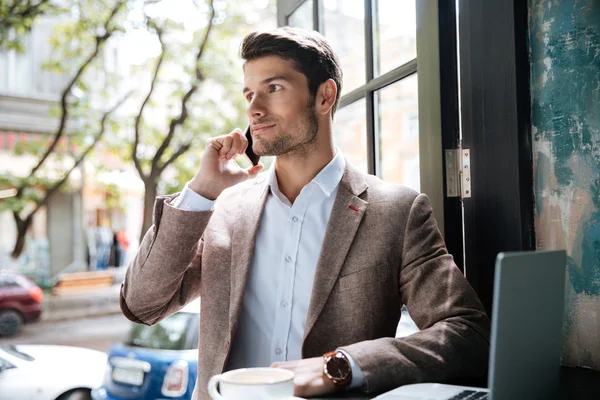 Young handsome businessman making phone call in cafe — Stock Photo, Image