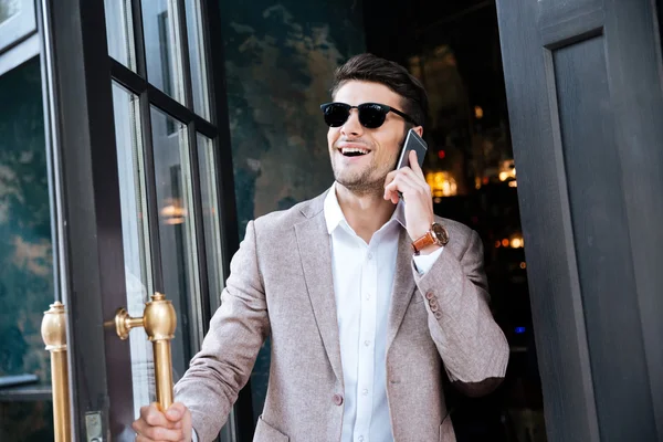 Επιχειρηματίας, μιλώντας στο κινητό τηλέφωνο και περπάτημα έξω από το καφενείο — Φωτογραφία Αρχείου