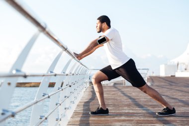 Boş ekran smartphone müzik ve germe sporcu