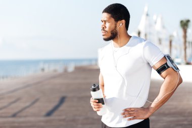 Yakışıklı sporcu ayakta ve içme suyu açık havada