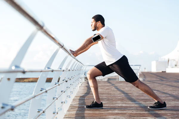 Boş ekran smartphone müzik ve germe sporcu