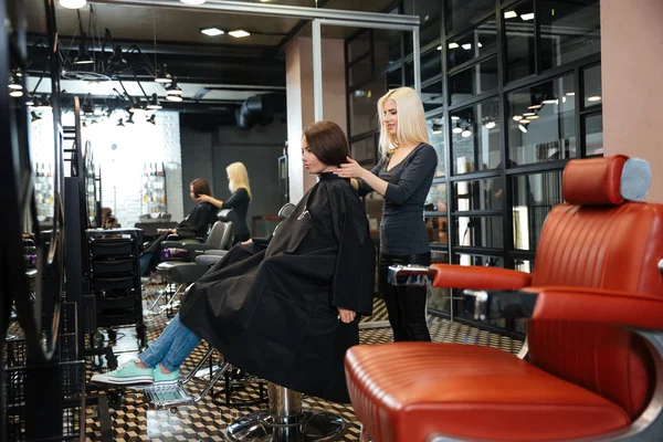 Jong meisje praten met Kapper in de beauty salon — Stockfoto