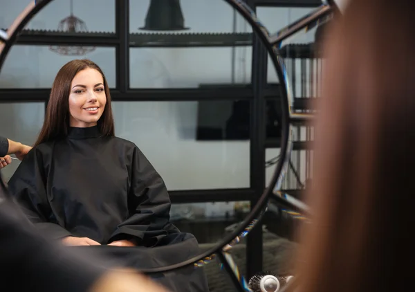 Odbicie lustrzane młodej kobiety coraz jej fryzurę przez stylista — Zdjęcie stockowe