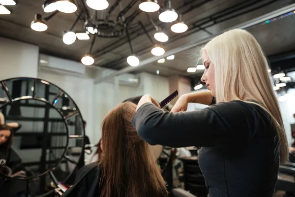 Mujer consiguiendo corte de pelo por peluquería femenina en salón de belleza — Foto de Stock