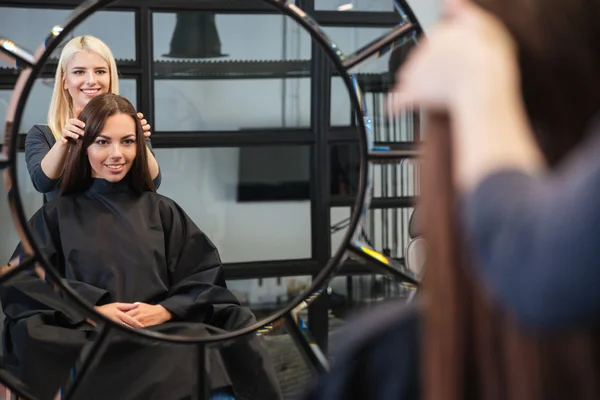 Espelho reflexo de mulher recebendo seu corte de cabelo por estilista — Fotografia de Stock