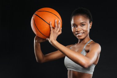 Basketbol siyah üzerinde tutan spor giyim mutlu kadın portresi