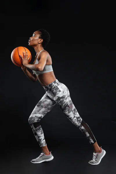 Retrato de cuerpo entero de una mujer deportiva sosteniendo pelota de baloncesto — Foto de Stock