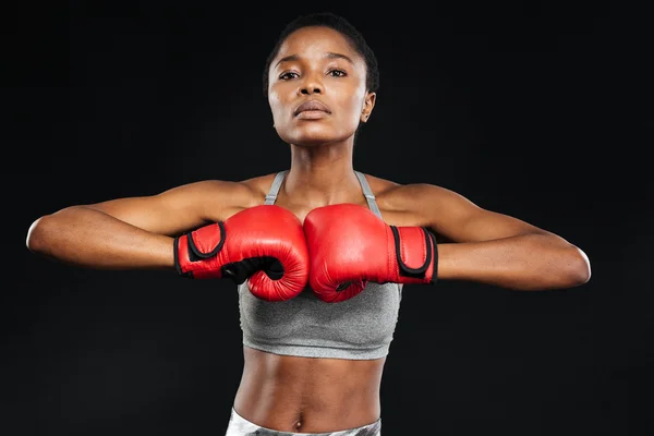 Mujer fitness posando con guantes de boxeo sobre fondo negro — Foto de Stock